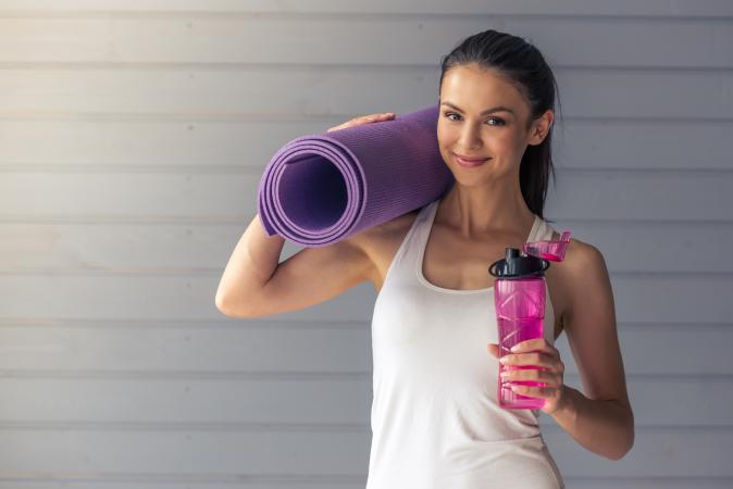 woman holding a yoga mat