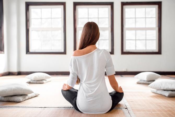Seated woman practicing yoga indoors